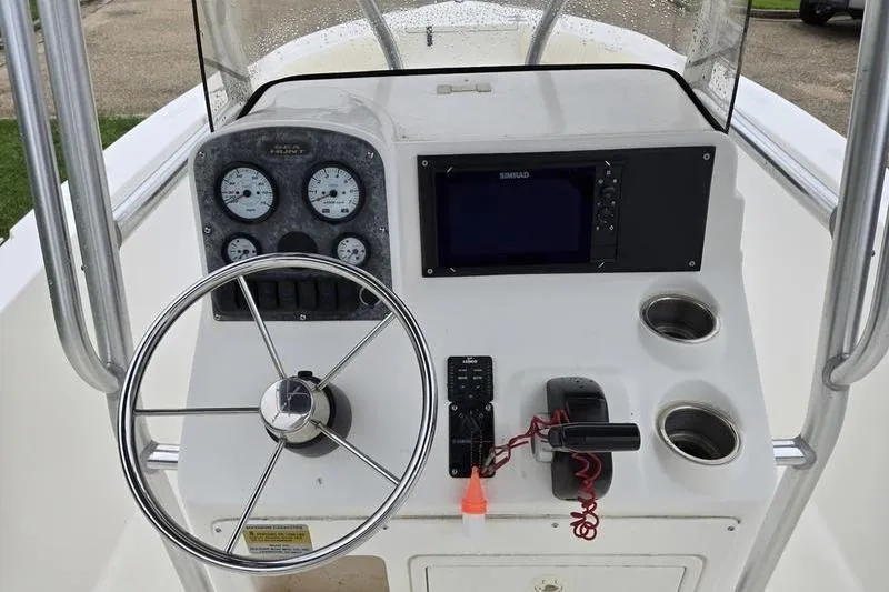 Slide: The Image of 2007 Sea Hunt Triton 220 boat dashboard with steering wheel, gauges, and navigation system. - 8
