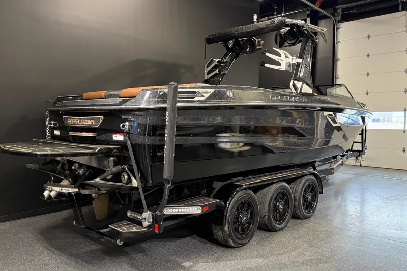 Slide: The Image of 2021 Centurion Ri265 boat on trailer in showroom, black exterior, sleek design. - 3