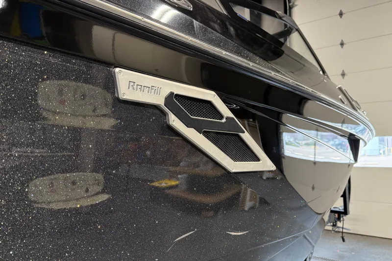 Slide: The Image of 2021 Centurion Ri265 boat with Ramfill feature, black exterior, in a garage setting. - 8