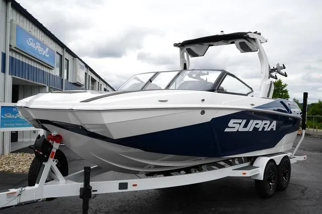 The Image of 2026 Supra SA boat on trailer, sleek design, parked outdoors. - 1