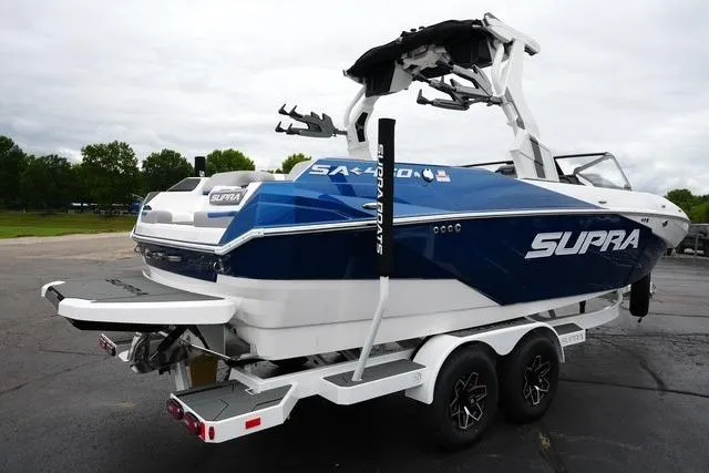Slide: The Image of 2026 Supra SA boat on trailer, blue and white design, parked outdoors. - 5