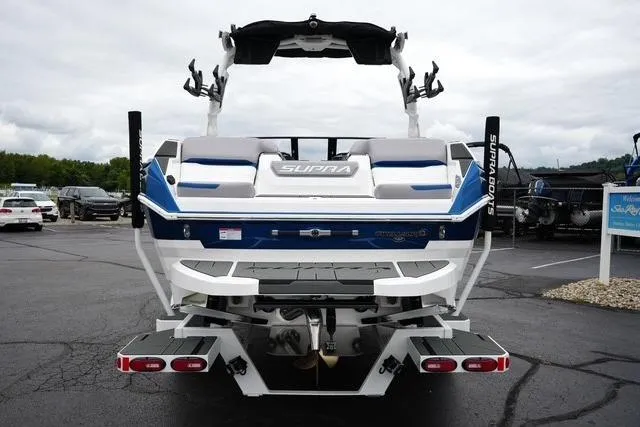 Slide: The Image of 2026 Supra SA boat, rear view, parked on asphalt, showcasing sleek design and features. - 6