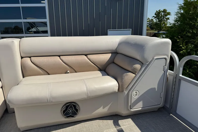 Slide: The Image of 2007 Manitou Aurora boat seating with beige upholstery and speaker, outdoors. - 15
