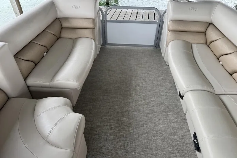 Slide: The Image of 2007 Manitou Aurora pontoon boat with beige seating and marina logo, parked outdoors. - 5