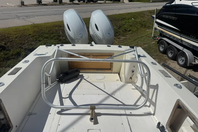Slide: The Image of 1986 Mako Express boat deck with dual Suzuki outboard motors, parked near a road. - 3