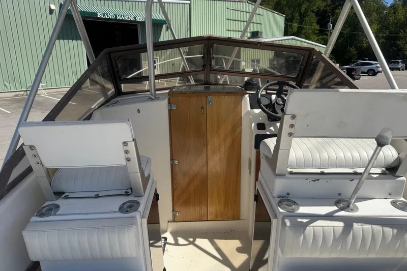 Slide: The Image of 1986 Mako Express boat interior with white seating and wooden console. - 4