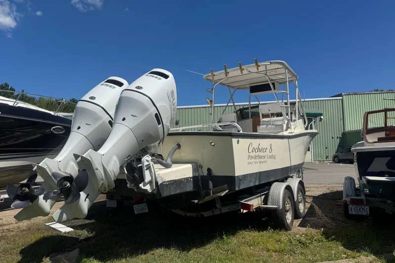 Slide: The Image of 1986 Mako Express boat on trailer with dual outboard motors, parked outdoors. - 7