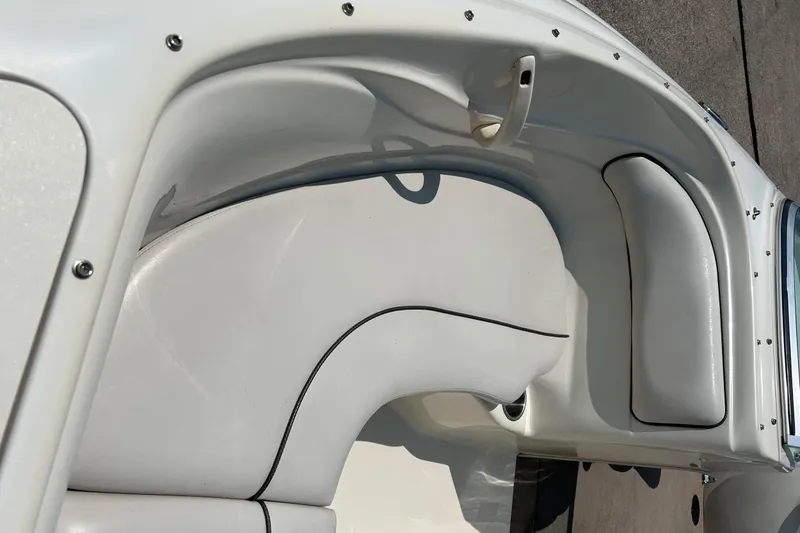 Slide: The Image of 2003 Sea Ray 182 SRX Bow Rider boat interior with white seating and open windshield. - 9