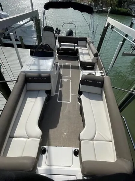 Slide: The Image of 2020 Bayliner Element XR7 boat with spacious seating and modern design, docked by the water. - 11