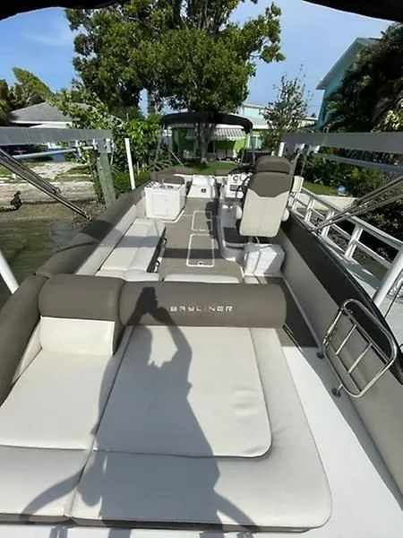 Slide: The Image of 2020 Bayliner Element XR7 boat with spacious seating and modern design, docked near lush greenery. - 12