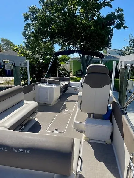 Slide: The Image of 2020 Bayliner Element XR7 boat interior with seating and canopy, docked outdoors. - 15
