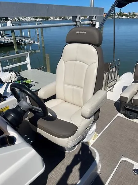 Slide: The Image of Captain's seat on 2020 Bayliner Element XR7 boat, docked by the water. - 20