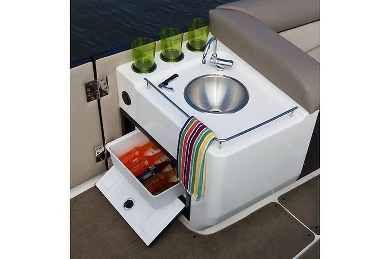 Slide: The Image of 2020 Bayliner Element XR7 boat kitchenette with sink, storage, and green glasses. - 21