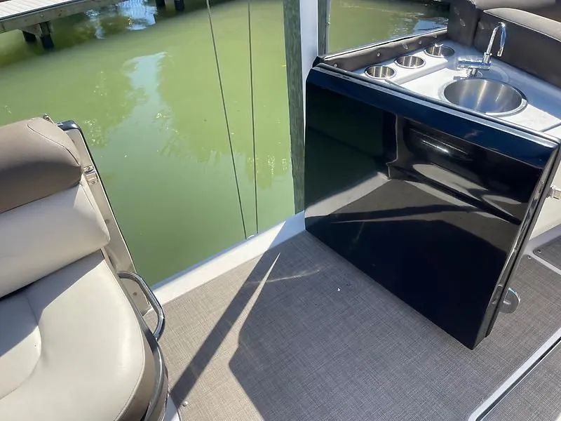 Slide: The Image of 2020 Bayliner Element XR7 boat interior with seating and kitchenette area. - 25