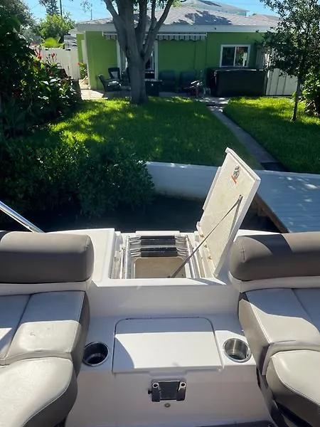 Slide: The Image of 2020 Bayliner Element XR7 boat interior with open storage compartment, docked near a green house. - 28