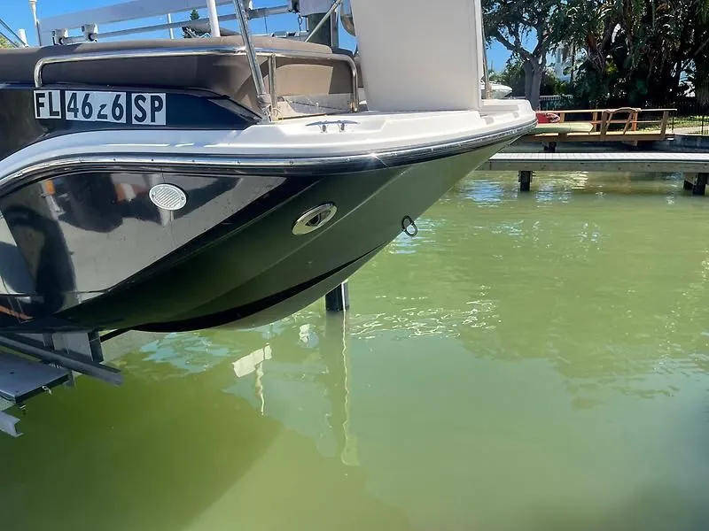Slide: The Image of 2020 Bayliner Element XR7 boat docked on green water, rear view. - 3