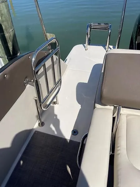 Slide: The Image of 2020 Bayliner Element XR7 boat interior with seating and railing, docked by the water. - 34