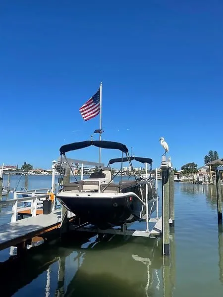 Slide: The Image of 2020 Bayliner Element XR7 docked with American flag, clear blue sky, and waterfront view. - 6