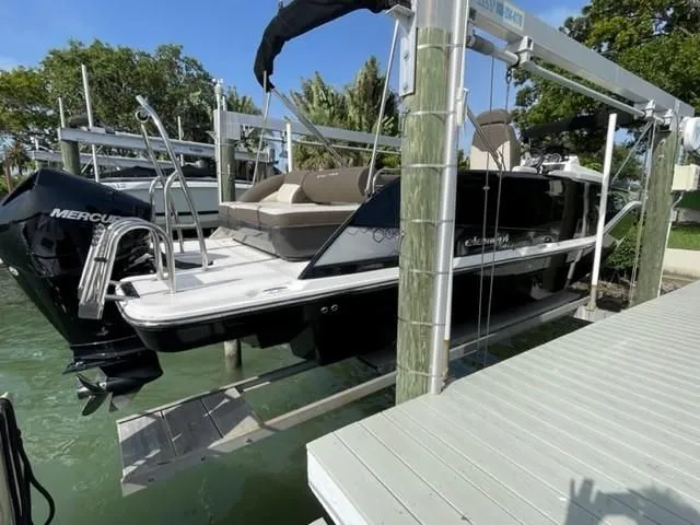 Slide: The Image of 2020 Bayliner Element XR7 boat on lift by dock, featuring Mercury engine. - 9