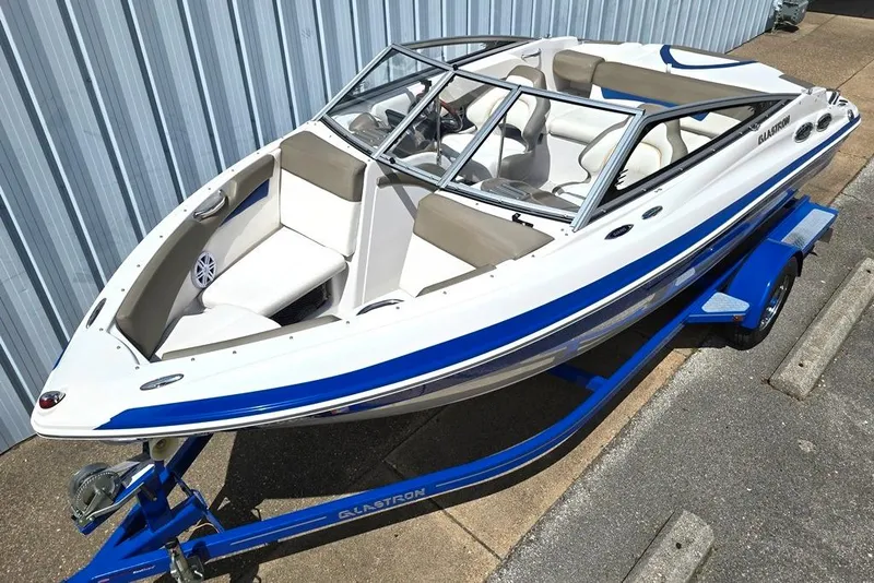 Slide: The Image of 2013 Glastron GLS 195 BR boat on trailer, featuring sleek design and blue accents. - 1