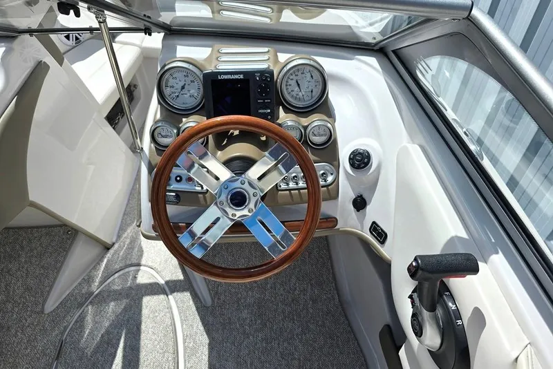 Slide: The Image of 2013 Glastron GLS 195 BR boat dashboard with gauges and wooden steering wheel. - 14