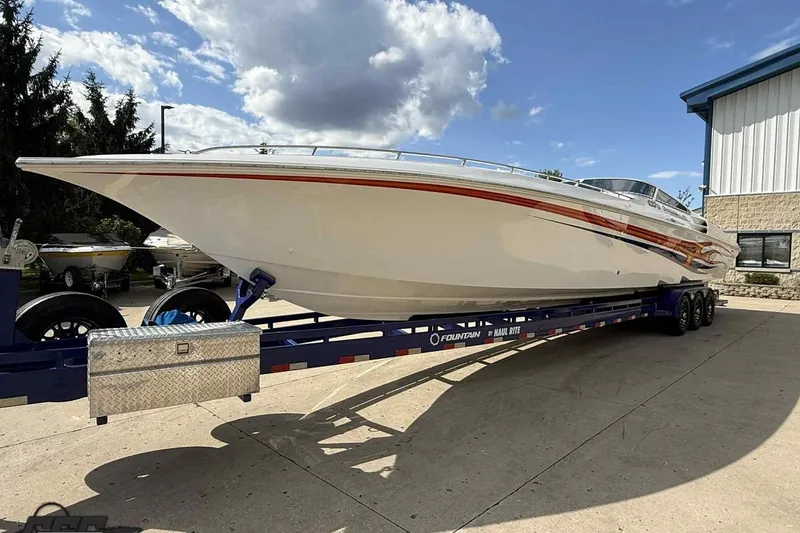 Slide: The Image of 2006 Fountain 47 Lightning speedboat on trailer under a partly cloudy sky. - 10