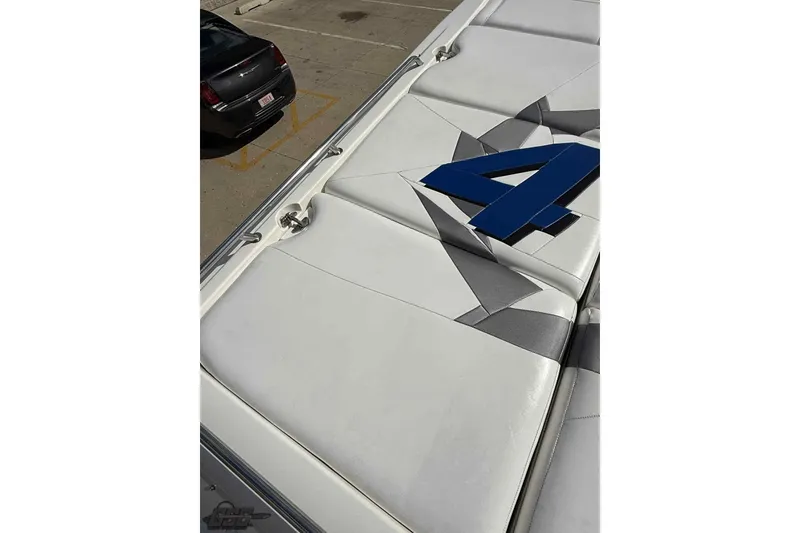Slide: The Image of 2006 Fountain 47 Lightning boat with sleek white and gray upholstery, featuring a bold blue "4". - 18