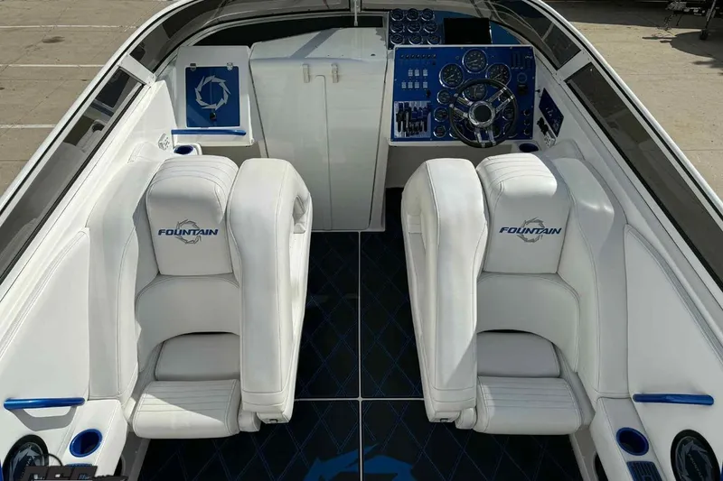 Slide: The Image of 2006 Fountain 47 Lightning boat interior with white seats and blue dashboard. - 24