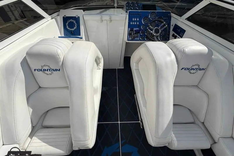 Slide: The Image of 2006 Fountain 47 Lightning boat interior with white seats and blue dashboard. - 27