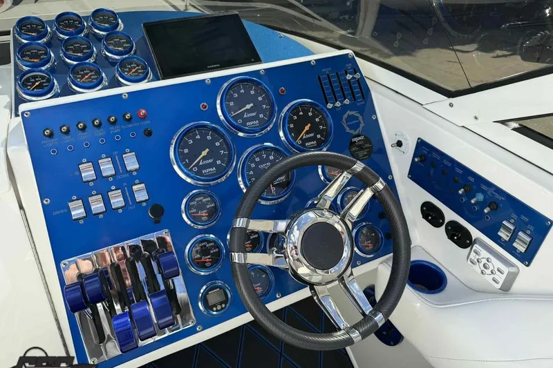 Slide: The Image of Control panel of a 2006 Fountain 47 Lightning boat with gauges and steering wheel. - 30