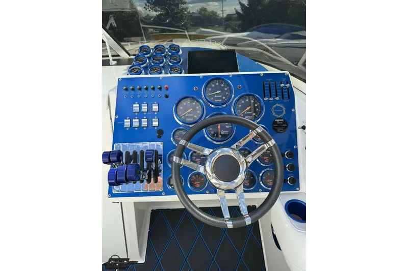 Slide: The Image of 2006 Fountain 47 Lightning boat dashboard with blue controls and gauges. - 31