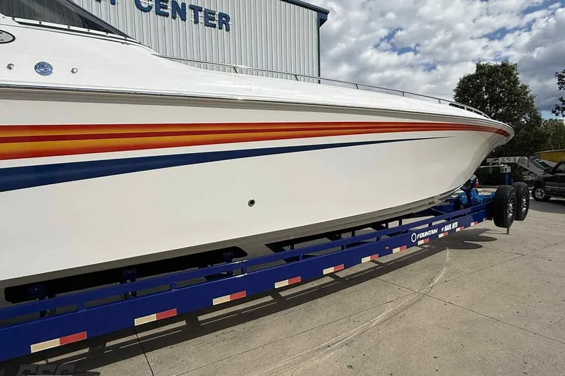 Slide: The Image of 2006 Fountain 47 Lightning boat on trailer, white with orange and blue stripes. - 5