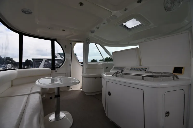 Slide: The Image of 2005 Sea Ray 390 Motor Yacht interior with seating, table, and kitchenette. - 18