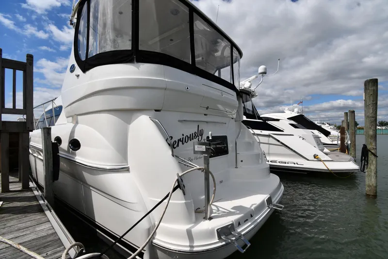Slide: The Image of 2005 Sea Ray 390 Motor Yacht docked at marina, clear sky, adjacent to another boat. - 3