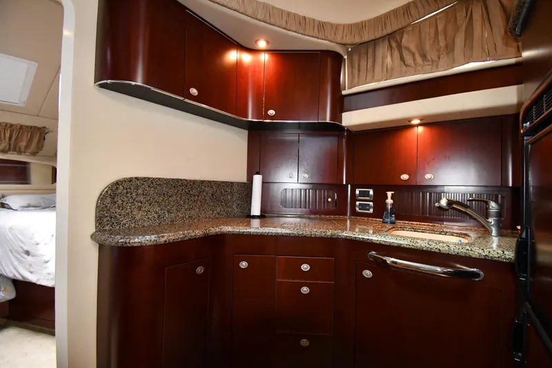 Slide: The Image of Luxurious 2005 Sea Ray 390 Motor Yacht kitchen with granite countertops and rich wood cabinetry. - 41