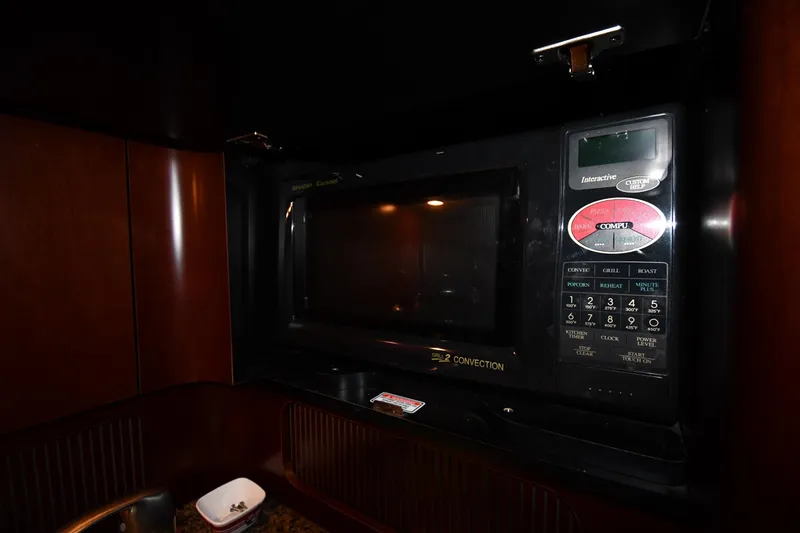 Slide: The Image of Microwave in 2005 Sea Ray 390 Motor Yacht kitchen, featuring dark wood cabinetry. - 46