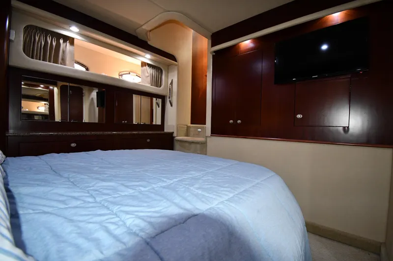 Slide: The Image of Luxurious 2005 Sea Ray 390 Motor Yacht bedroom with blue bedding and wood cabinetry. - 54