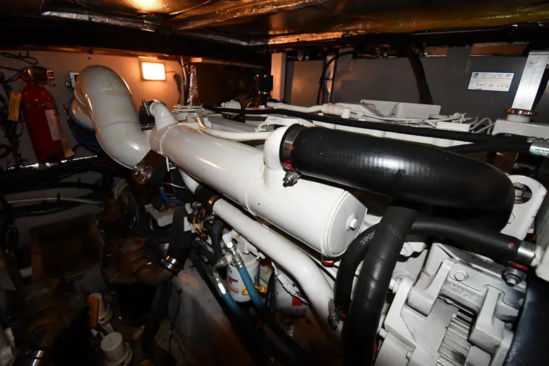 Slide: The Image of Engine room of 2005 Sea Ray 390 Motor Yacht, featuring complex piping and components. - 65