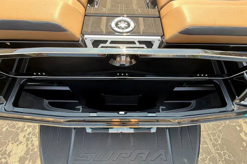 Slide: The Image of 2026 Supra SE 550 boat interior storage compartment with tan seating and sleek design. - 8