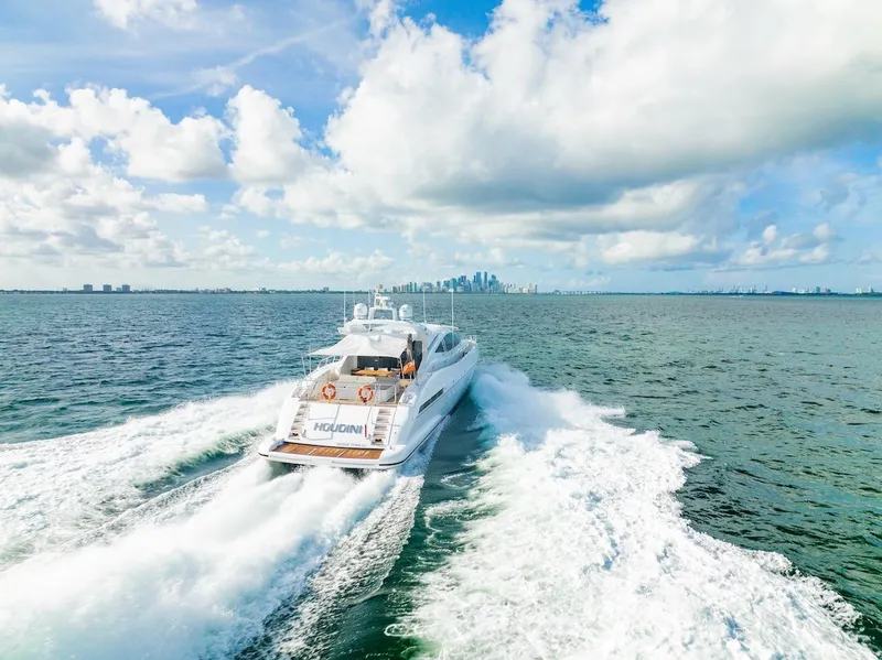 Slide: The Image of Mangusta 92 yacht cruising on open water, 2007 model, with city skyline in background. - 21