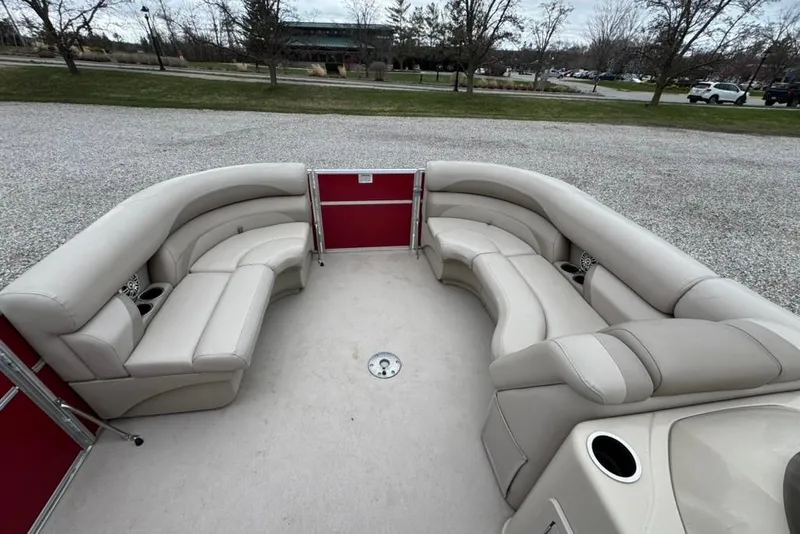 Slide: The Image of 2017 Starcraft EX 20 RDP pontoon boat interior with beige seating and red paneling. - 18