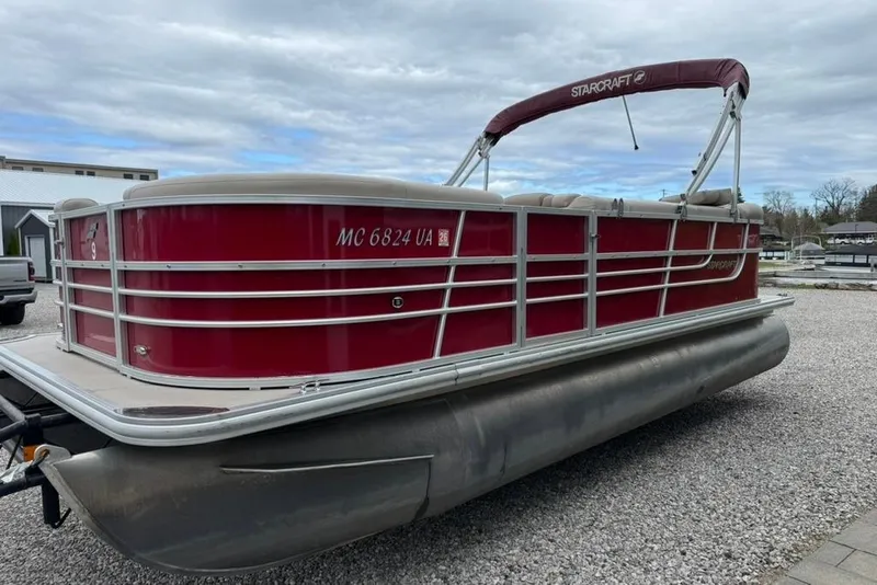 Slide: The Image of 2017 Starcraft EX 20 RDP pontoon boat with red exterior, parked on gravel. - 8