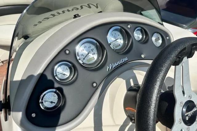 Slide: The Image of Dashboard of 2017 Manitou 23 Oasis boat with gauges and steering wheel. - 12