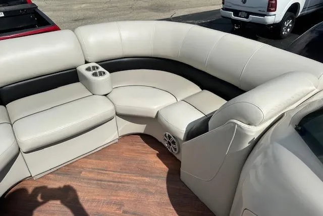 Slide: The Image of 2017 Manitou 23 Oasis boat interior with beige seating and cup holders. - 14