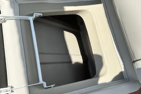 Slide: The Image of Open storage compartment on 2017 Manitou 23 Oasis boat, featuring a sleek design. - 20