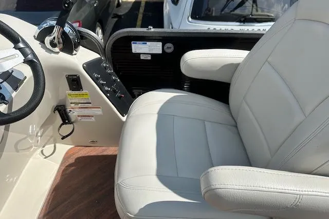 Slide: The Image of Captain's seat and controls of a 2017 Manitou 23 Oasis boat. - 22