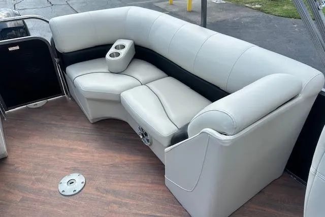 Slide: The Image of 2017 Manitou 23 Oasis boat interior with plush seating and cup holders. - 27