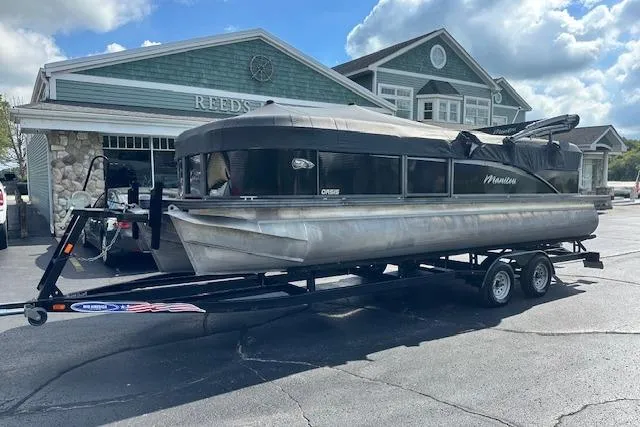 Slide: The Image of 2017 Manitou 23 Oasis pontoon boat on trailer, parked outside a building. - 31