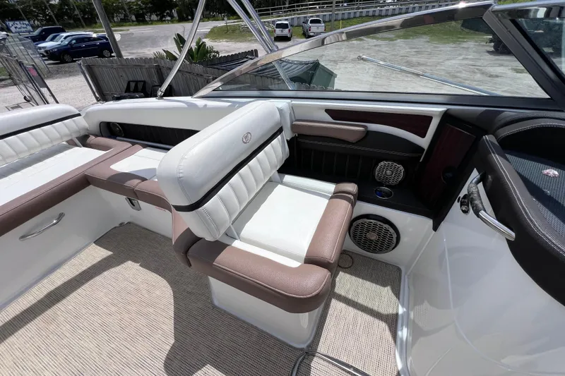 Slide: The Image of 2015 Cobalt 26SD boat interior with white and brown seating, speakers, and carpeted flooring. - 22