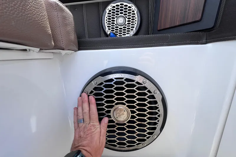 Slide: The Image of Hand touching speaker on 2015 Cobalt 26SD boat interior. - 24